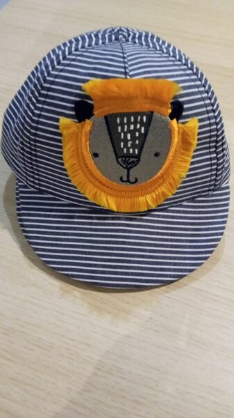 Naģene strīpaina gaiši pelēks, balt, ar pelēku lauvas galvu un oranžām spalvām apkārt 0-3 mēneši