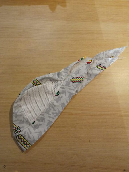 Plāna cepurīte pelēka ar skrituļdēli, ar baltu sietiņu augšā, sasienama aizmugure 44-48 izmērs